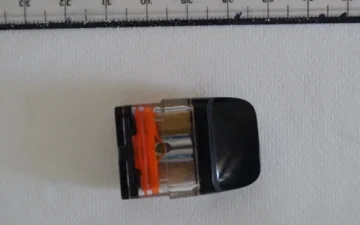 Cartouche de vape photographiée à côté d'une règle, échantillon envoyé au laboratoire